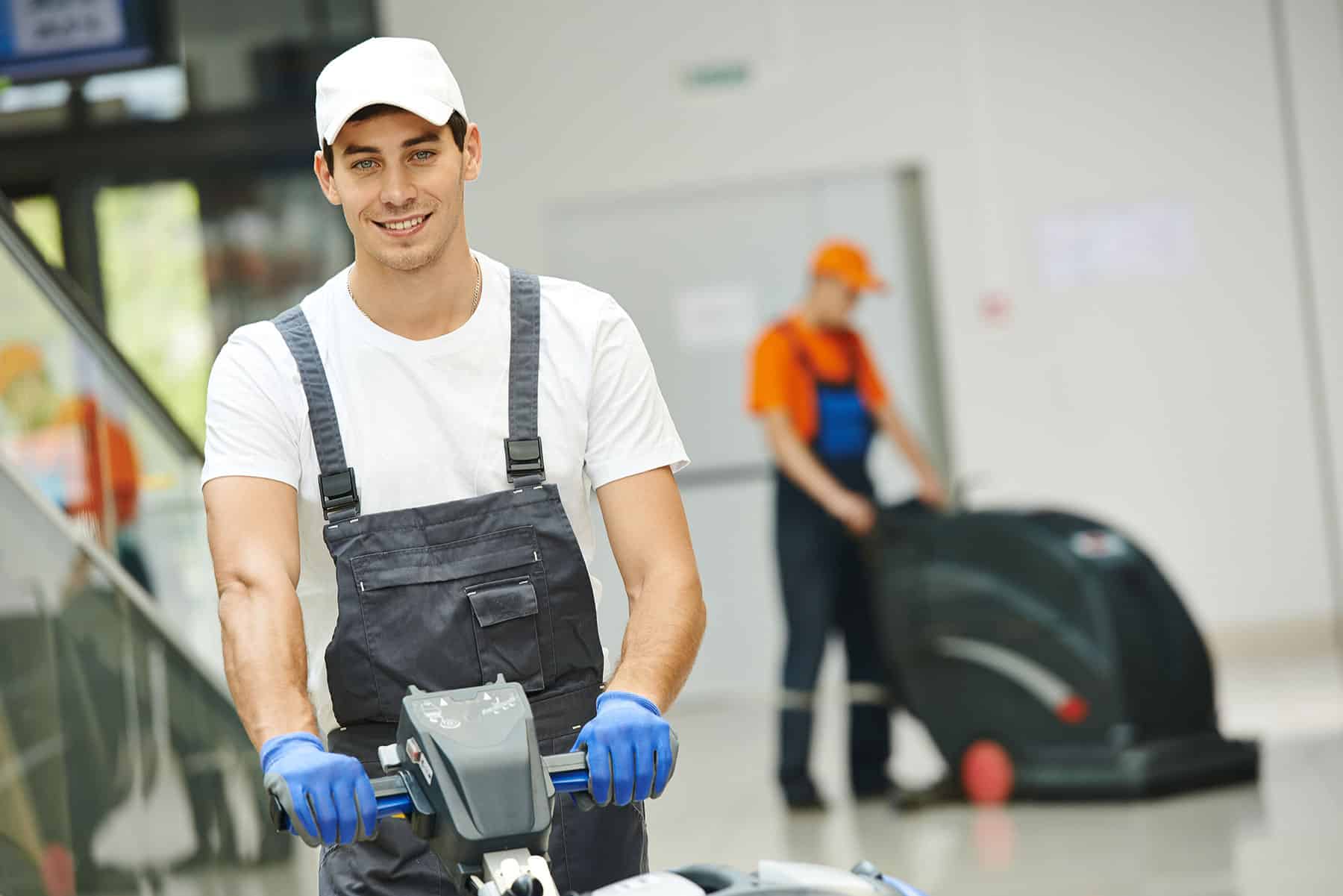 Two men cleaning a floor with industrial floor washer